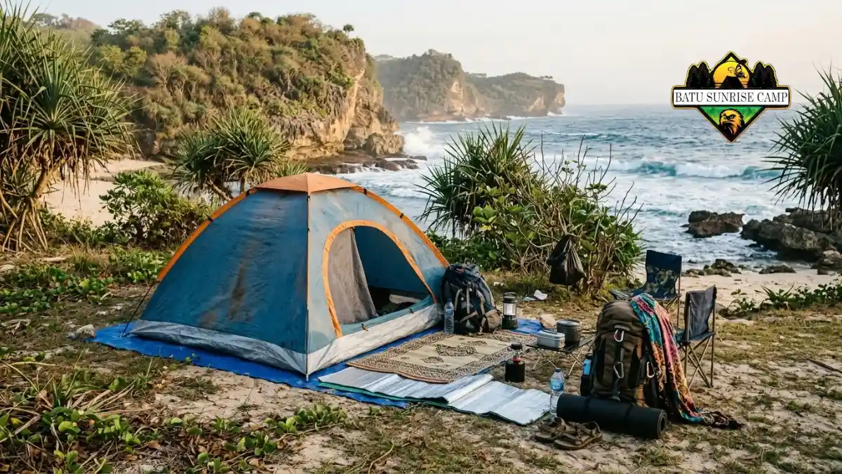 Tenda camping dome lengkap dengan perlengkapan ransel, matras, dan peralatan masak di tepi pantai karang Gunungkidul
